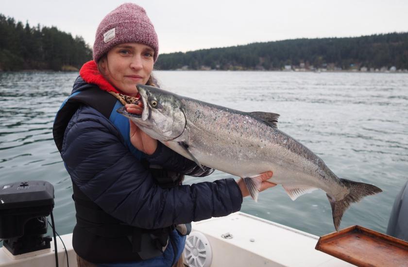 Angler holds up a blackmouth salmon she caught