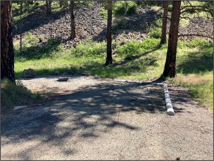 Finished camping pad with packed gravel, bumpers, and fire ring