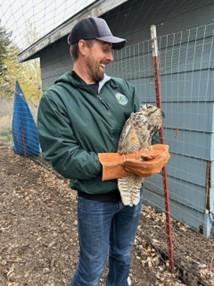 A staff member holding a great horned owl. 