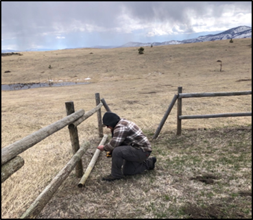 Staff member Rise making repairs to the Silverhill parking area split rail fence.
