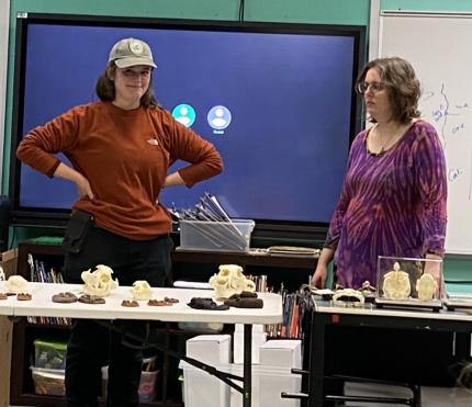 Technician Balderson and Nason in front of a table with animal skulls